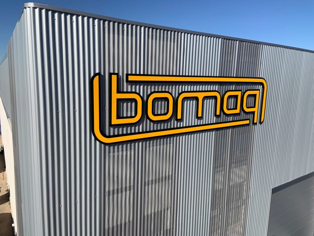 Rótulo corpóreo de gran formato 'Bomaq' sobre fachada de paneles industriales, proyecto de Rótulos Marcos.